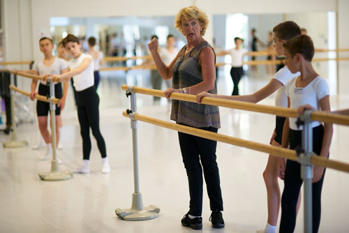 Group of boys surrounding a teacher at the barre