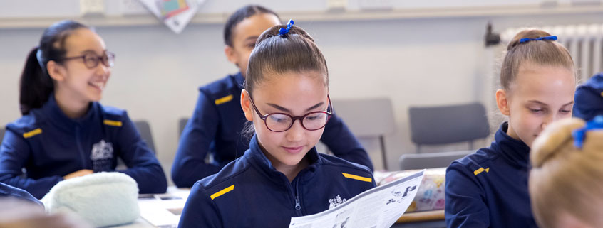 Student reading a worksheet in a classroom.