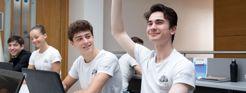 Students in an academic class, one student is raising their hand to ask a question