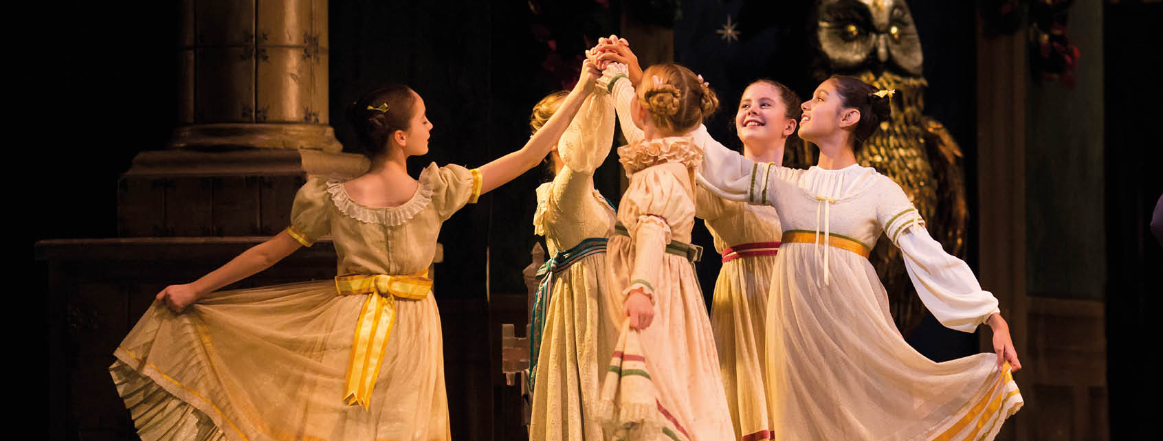 A group of students dance in a circle, smiling at each other