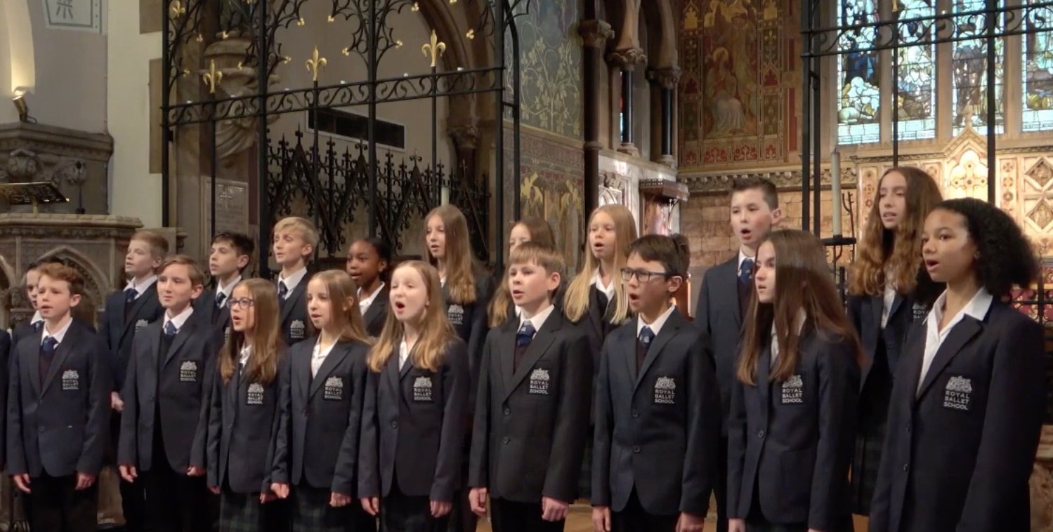 Students stand at the front of a church singing christmas carols