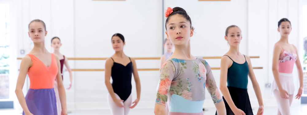International masterclasses - barcelona Girls all wearing colourful leotards ready to start their ballet class in a white studio