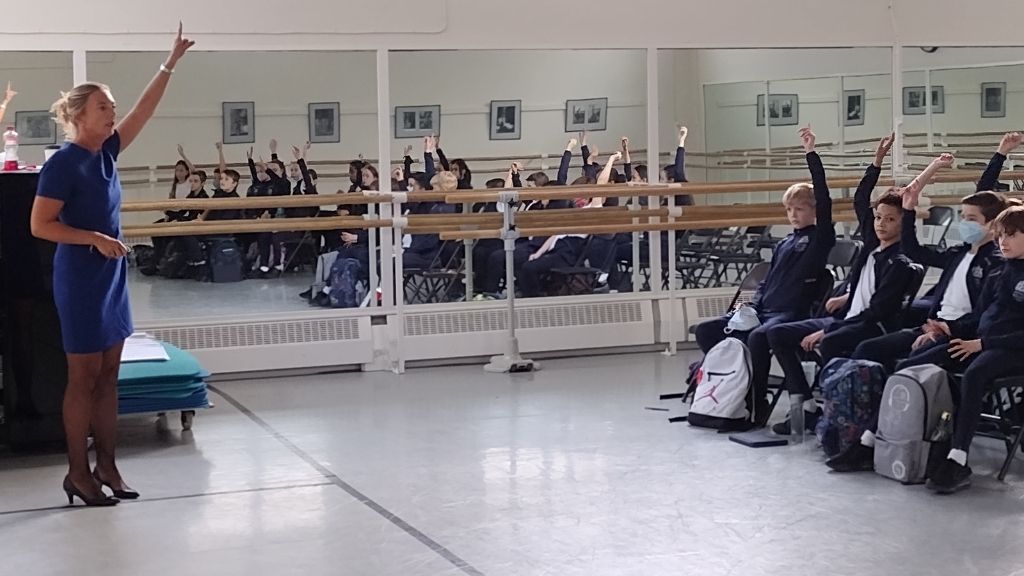 Children raise their hands in response to a question at an anti-bullying workshop