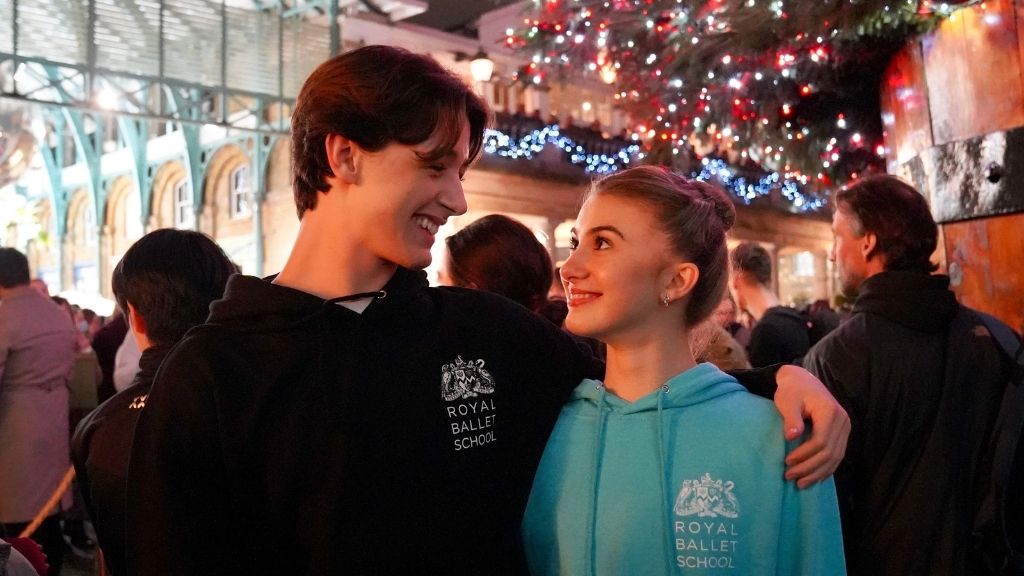 Students in royal ballet school hoodies stood infront of the covent garden christmas tree