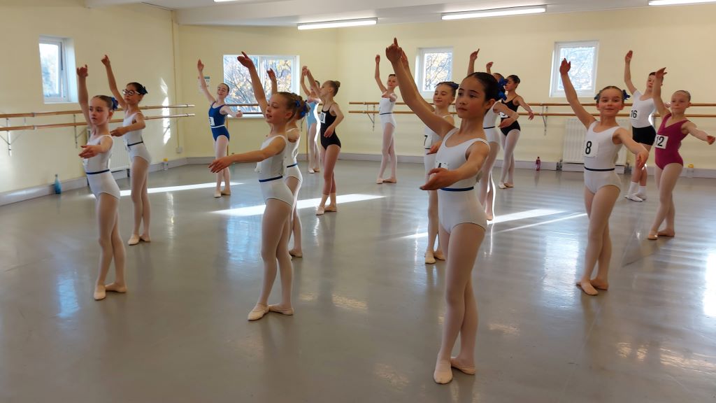 Young dancers wearing leotards audition in a dance studio for the royal ballet school