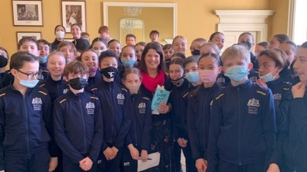 Catherine bruton stands with a group of students holding her book