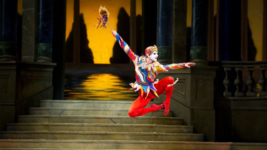 Paul kay dances as the jester in cinderella wearing a brightly-coloured costume and jumping with his arms outstretched