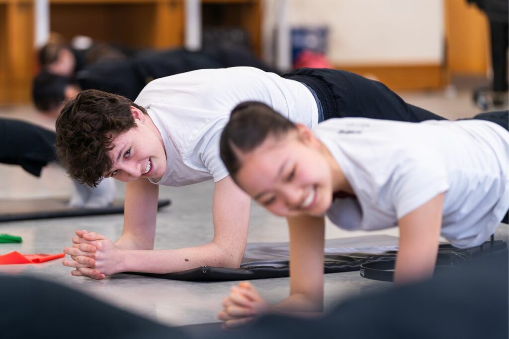 Two students doing a plank exercise for strength and conditioning class.
