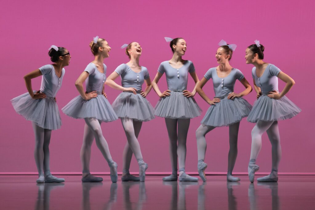 Six dancers smiling at each other