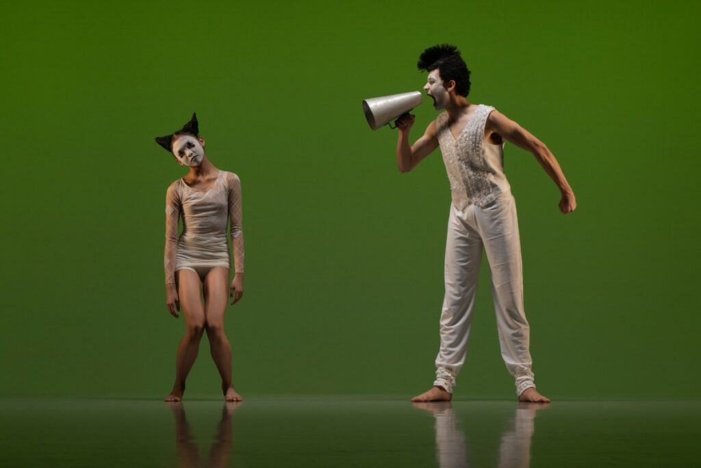 Female and male student with a microphone dressed as clowns performing didy veldman's toot
