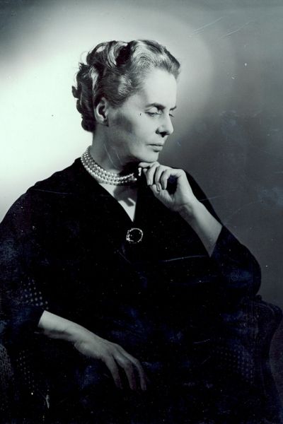 100 stories - arnold haskell Ninette de valois gazes down to the left with her left hand resting on her chin. She wears a long-sleeved black blouse with a round brooch.