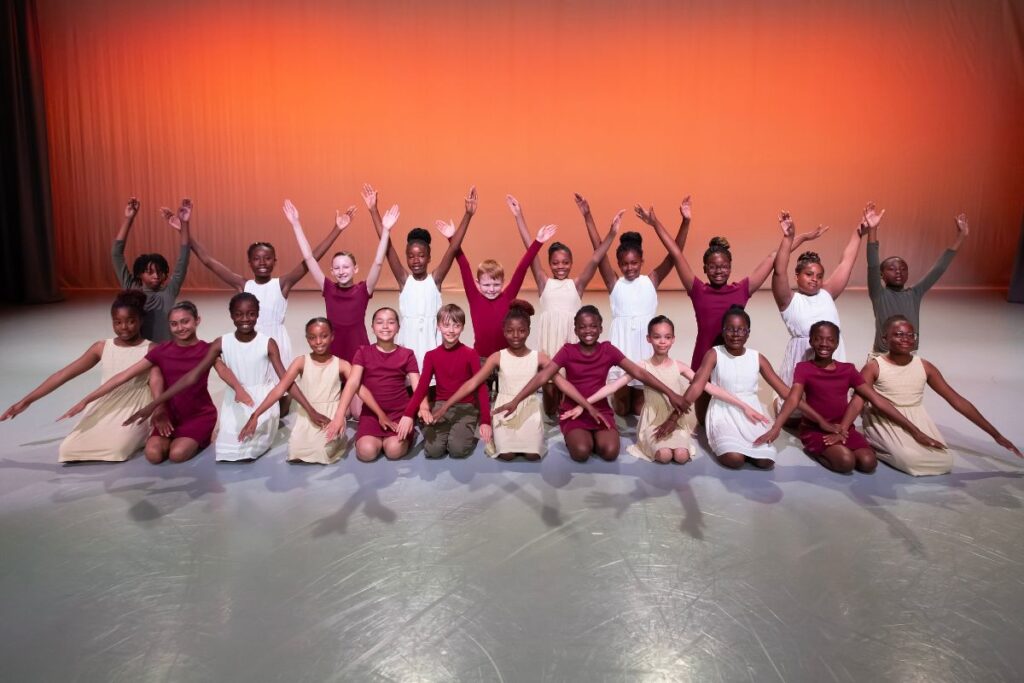 Young children posing for a photograph as a group in red and white costumes