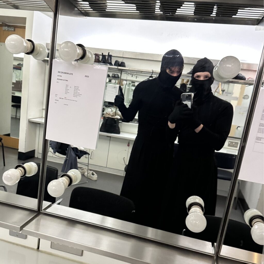 Julian and friend dressed in all black morph suits.