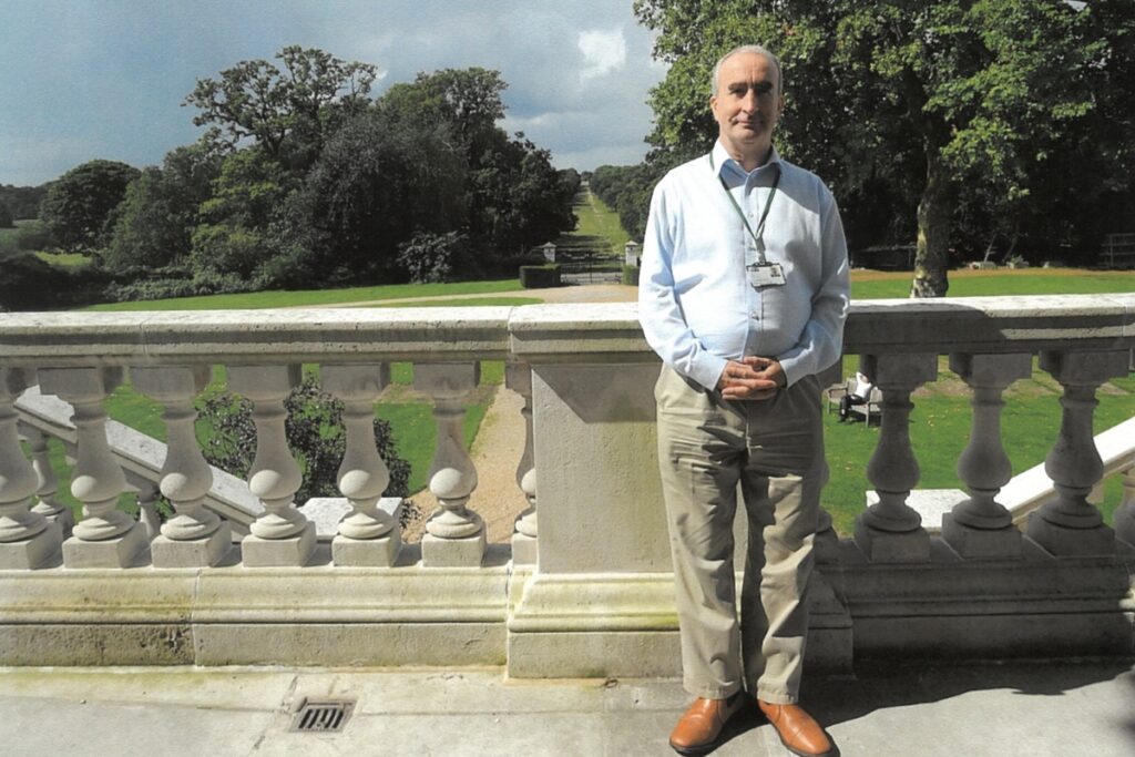 Ray standing on the white lodge balcony