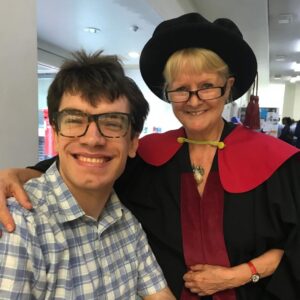 Joseph and susie pictured smiling together with susie wearing her doctoral regalia.