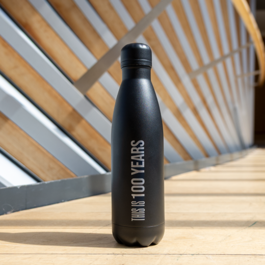 Black centenary water bottle from The Royal Ballet School, with text 'this is 100 years'.