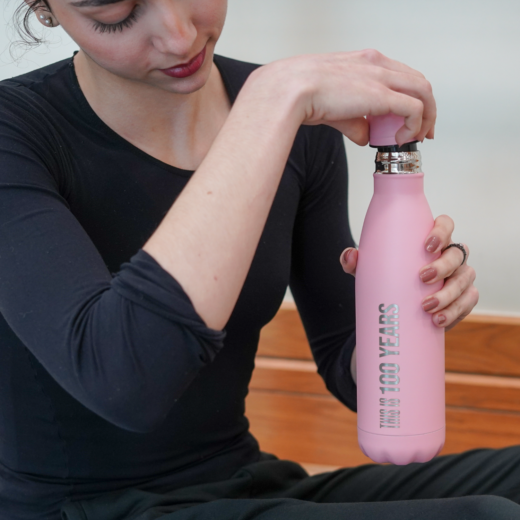 Pink centenary water bottle from The Royal Ballet School, with text 'this is 100 years'.