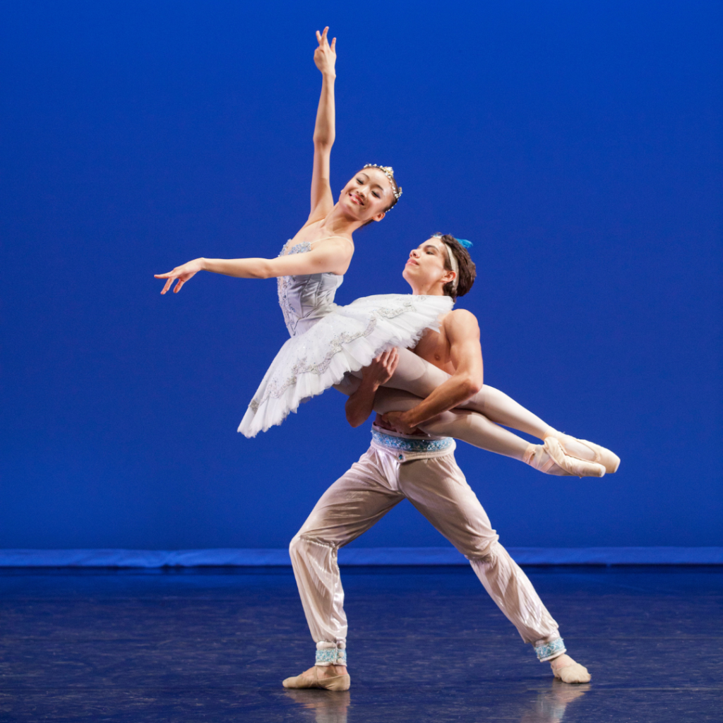 Yaoqian shang and esteban hernández performing against a blue background.