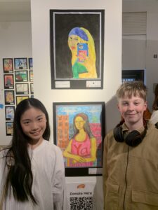 Chien-ning and myles smile in front of their colourful artwork