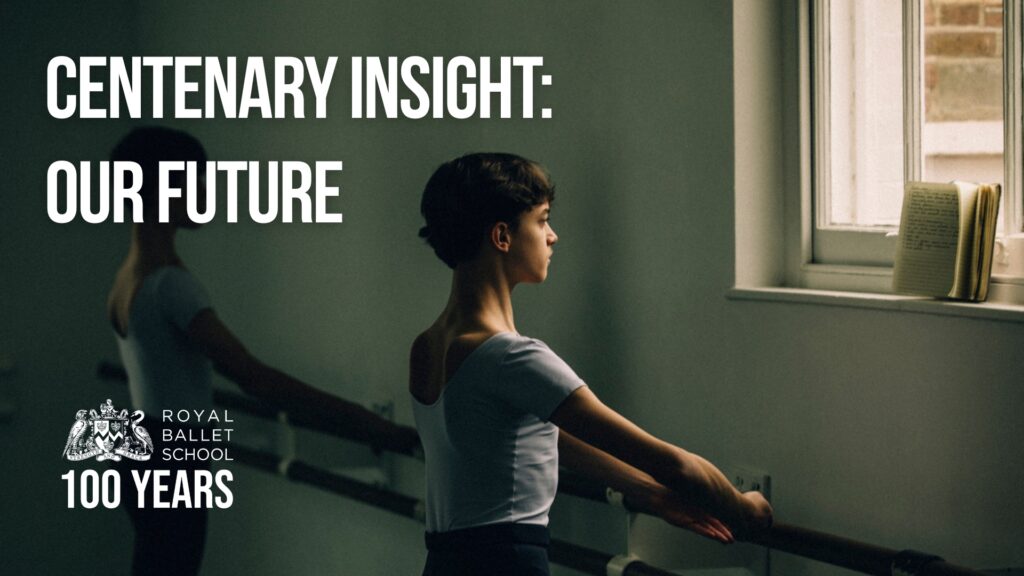 A boy stands at the bar in front of a window. An open notebook is on the windowsill, and the boy reads the notes while his hands are curved above the barre.