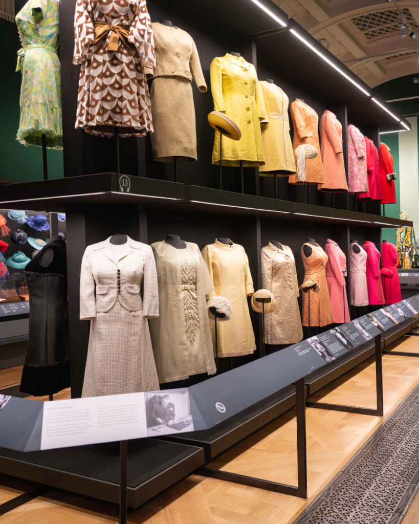 Two rows of colourful monochromatic dresses line a display case in the king's gallery