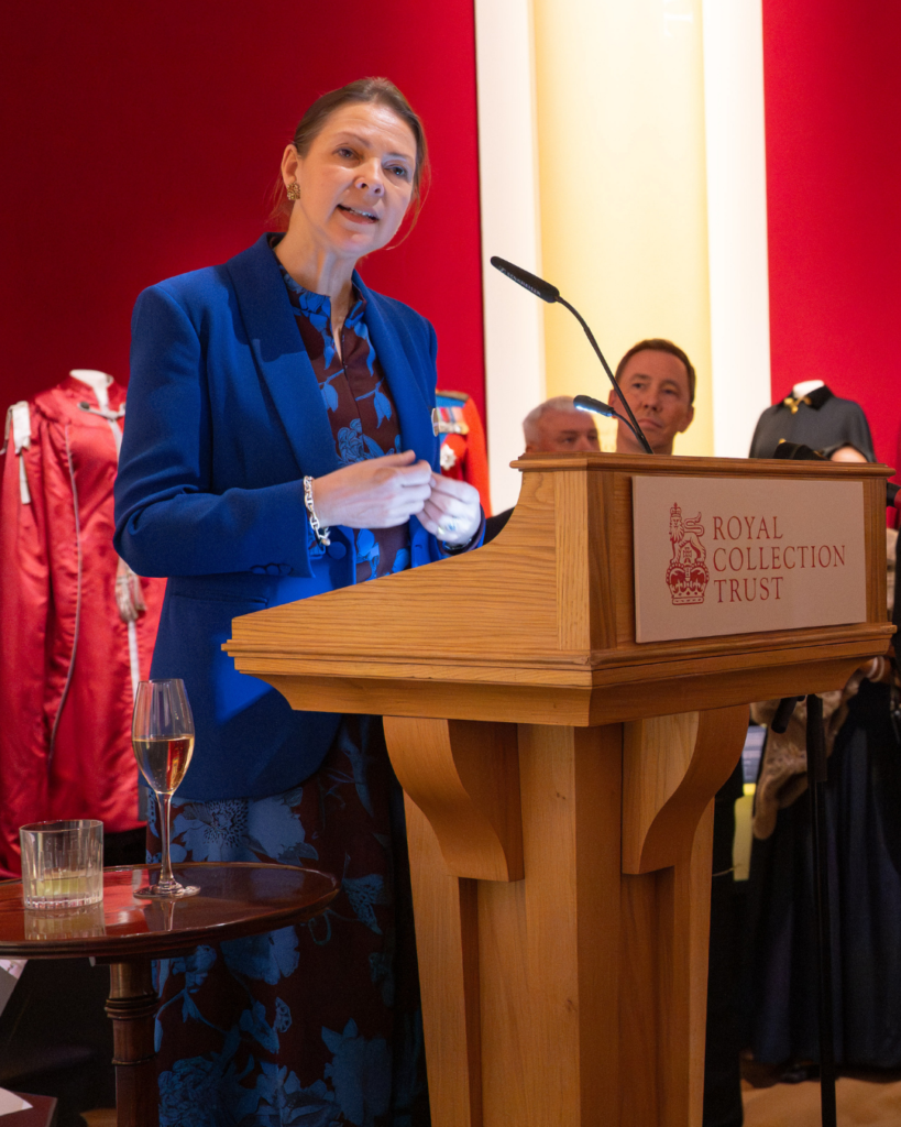 Caroline de guitaut speaks at a wooden podium in the gallery.