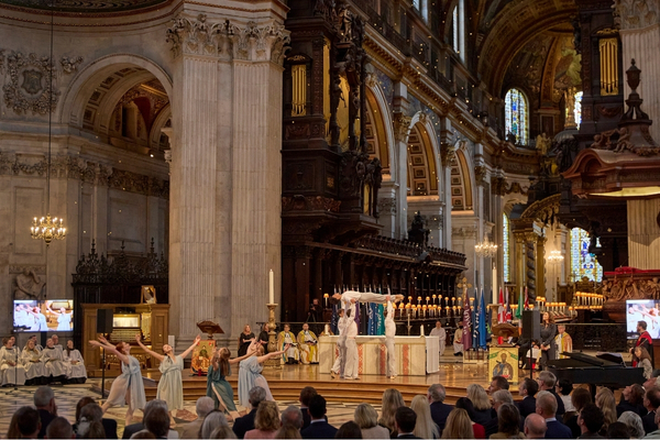 Student choreography shines at benefact group’s service of celebration at st paul's cathedral The dancers perform under the dome in the cathedral with golden flower petals falling from above.