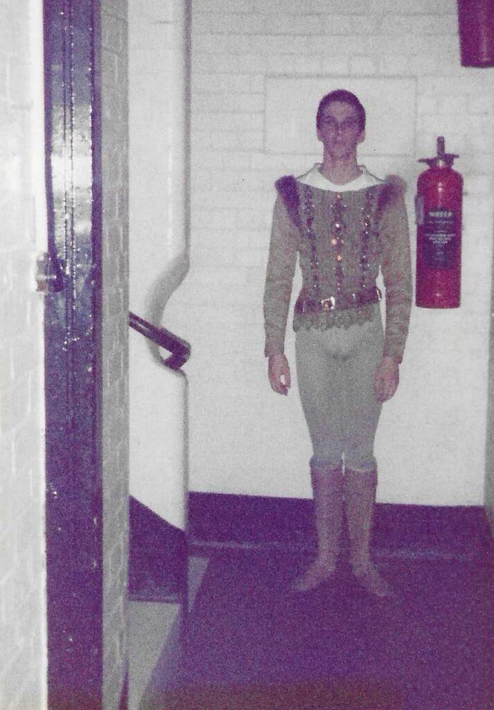 100 stories: christopher saunders Christopher wears light grey tights and a bejeweled tunic with boots.