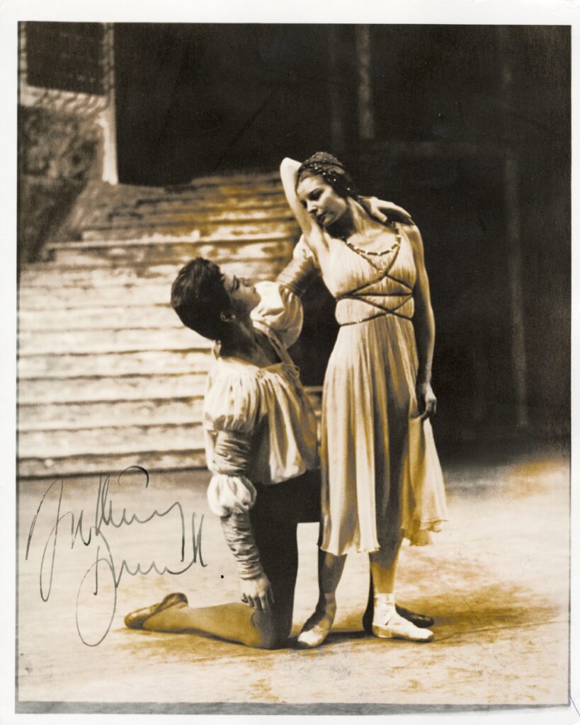 100 stories - anthony dowell and antoinette sibley Anthony kneels and reaches his left arm up around antoinette's shoulder. Antoinette stands in a casual second position with her right arm wrapped around her head to caress anthony's