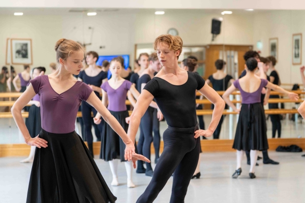 ‘refine all the time:’ alum samara downs on staging checkmate and swan lake for our summer performances A female dancer wears a purple leotard and black skirt. Her left arm is curved down with her hand flexed. Her light brown hair is in a bun. A male dancer mirrors her pose with his left hand on his hip. He wears a black shirt and tights. His blond hair falls lightly into his face.
