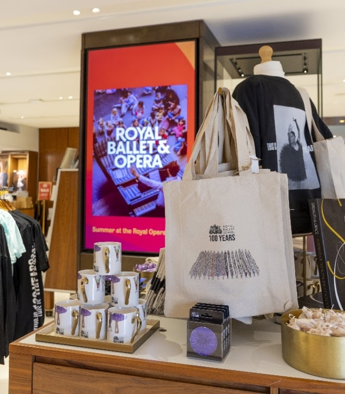 Behind the designs with centenary collection illustrators aimee tregunno and catja christensen A close up shot of the centenary merchandise table. Featured products are the grand défilé tote bag, tutu centenary cropped sweatshirt, through the years mugs and tutu coasters.