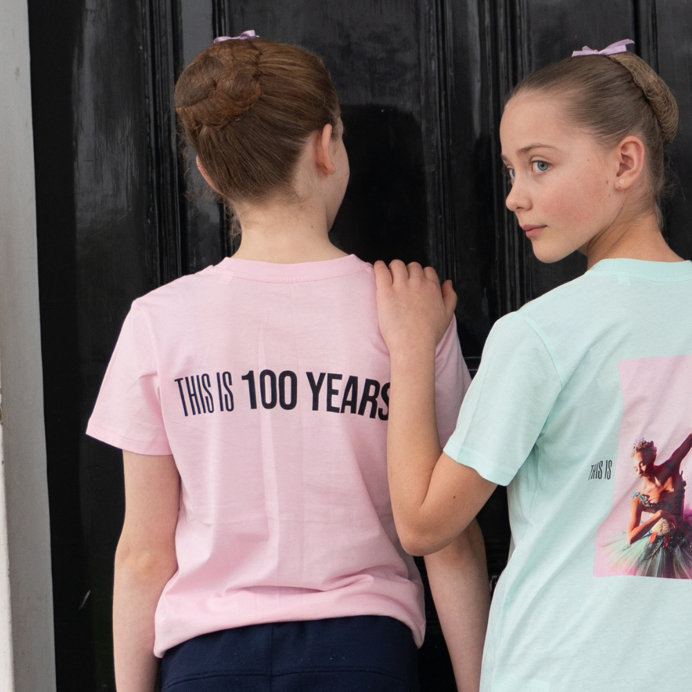This is 100 years children's t-shirt pink Product image of 'this is 100 years children's t-shirt' in pink. Worn by a royal ballet school student at white lodge. A collection of merchandise in celebration of 100 years of the royal ballet school.