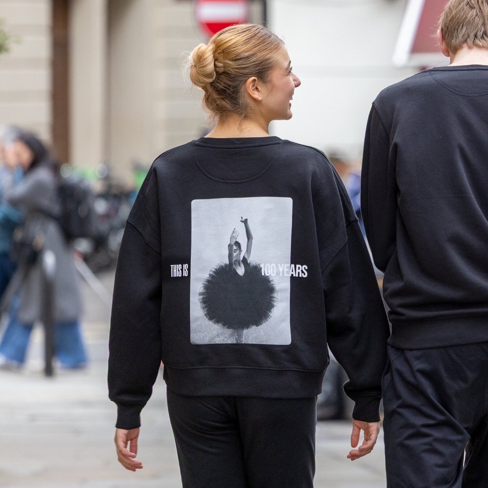 Tutu centenary cropped sweatshirt Product image of 'centenary rehearsal sweatshirt' in black. Worn by a royal ballet school student in upper school, covent garden. A collection of merchandise in celebration of 100 years of the royal ballet school.
