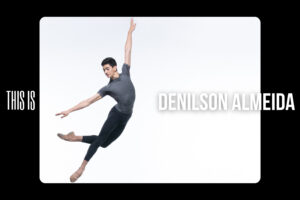 Denilson almeida 100 stories cover image - denilson jumps in front of a white backdrop. His upper body is tilted to the right with his right arm extended straight to the side and his left arm up on a high diagonal. His right leg is extended on a diagonal down to the right, and his left leg his crossed behind at the knee and bent.