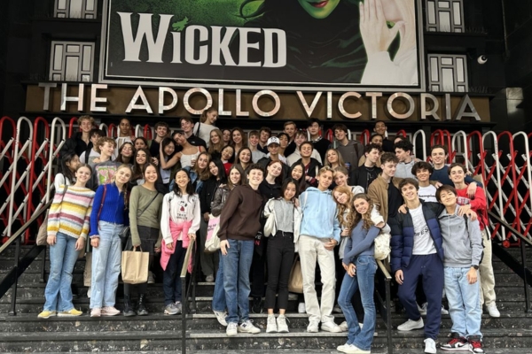 A day in the life of a full-time student at the royal ballet school A large group of white lodge students stand in front of the apollo victoria and a sign for wicked